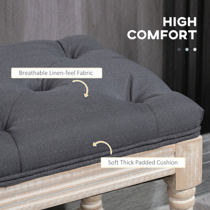 Grey linen bench with button-tufted seat placed at the foot of a bed, styled in a soft-toned bedroom setting, part of The Haddon Hall Still collection by The Timeless Trading Co.
