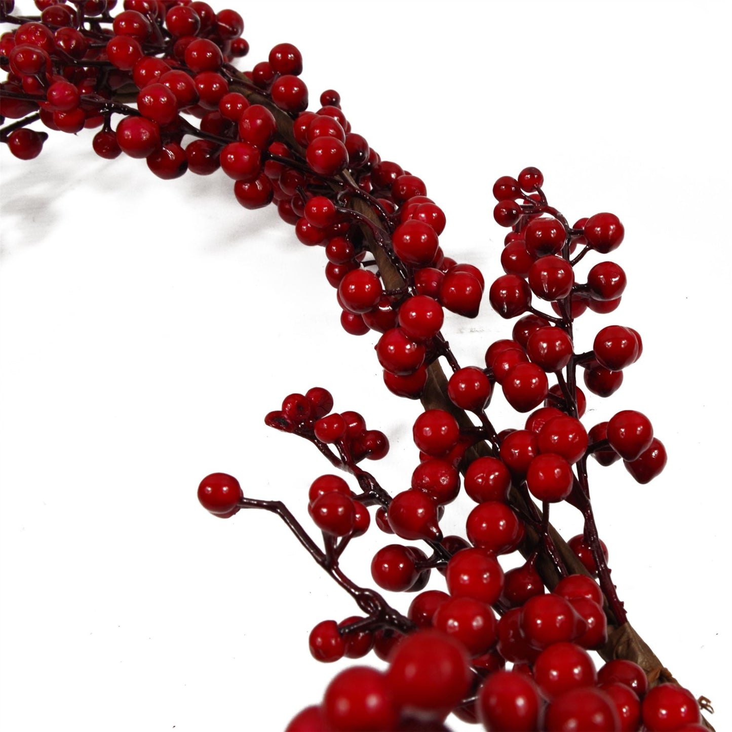 Close-up of red berries on Christmas garland with green foliage, rustic festive botanical detail