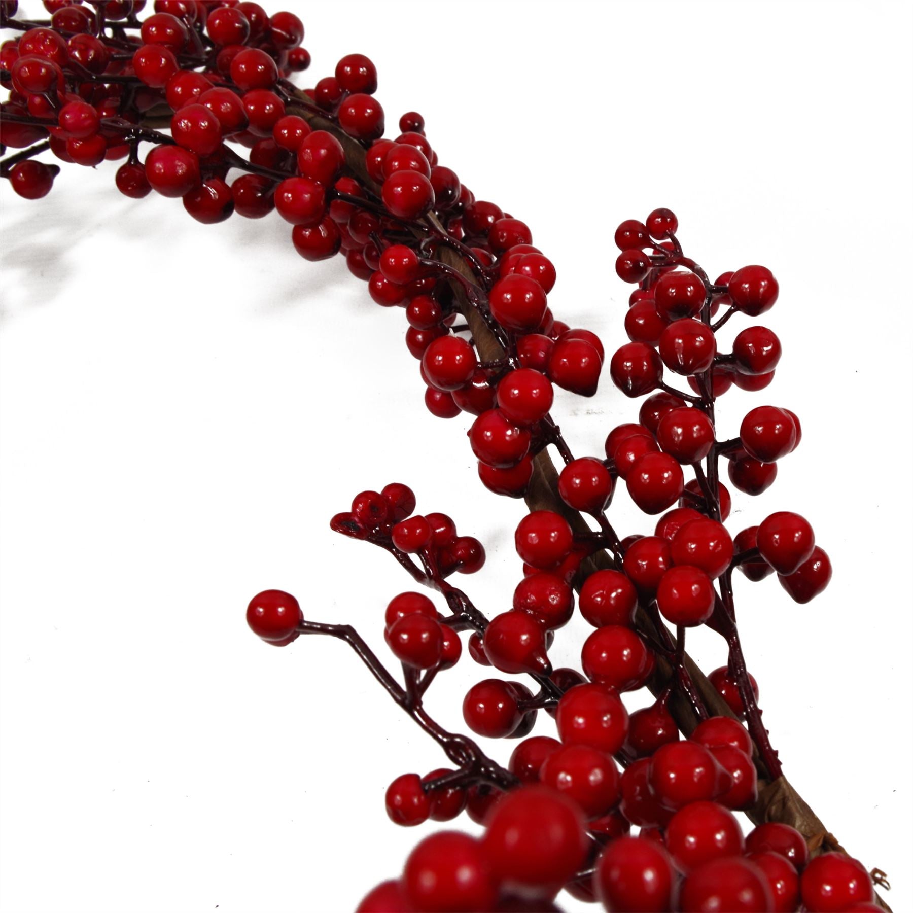 Close-up of red berries on Christmas garland with green foliage, rustic festive botanical detail