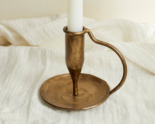 Iron candle holder brushed gold Ashbourne Hearth displayed on linen cloth with warm rustic styling

