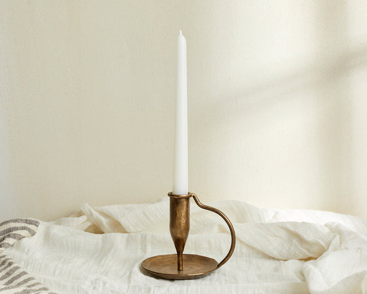 Iron candle holder brushed gold Ashbourne Hearth styled with tapered candle on linen cloth
