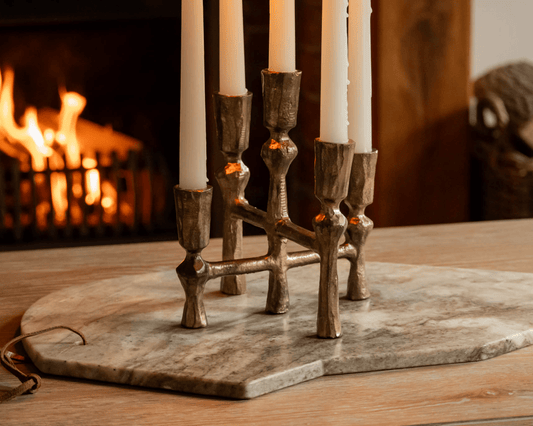 Pembroke iron candelabra five arm candleholder styled on coffee table with open fire in background
