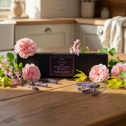 Rose geranium lavender ylang ylang wax melts in gift box on kitchen table surrounded with flowers
