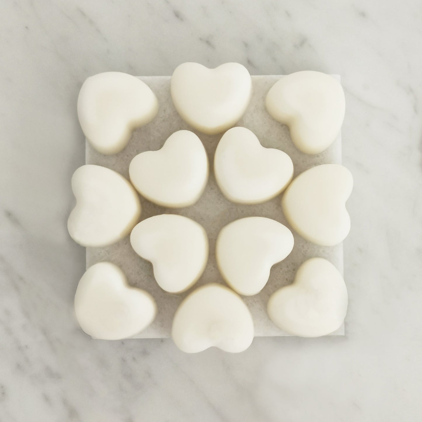 Rose geranium lavender ylang ylang wax melts with essential oils displayed on rustic tile surface
