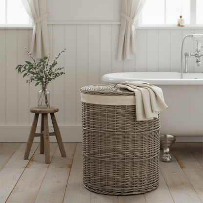 Round wicker laundry basket antique wash in beaded panelled bathroom with rolltop bath, wooden floor and milking stool
