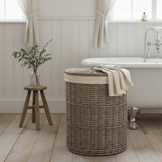 Round wicker laundry basket antique wash in beaded panelled bathroom with rolltop bath, wooden floor and milking stool
