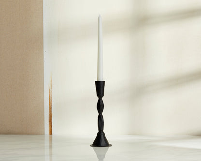 Sculptural black candle holder in blackened brass displayed on neutral background