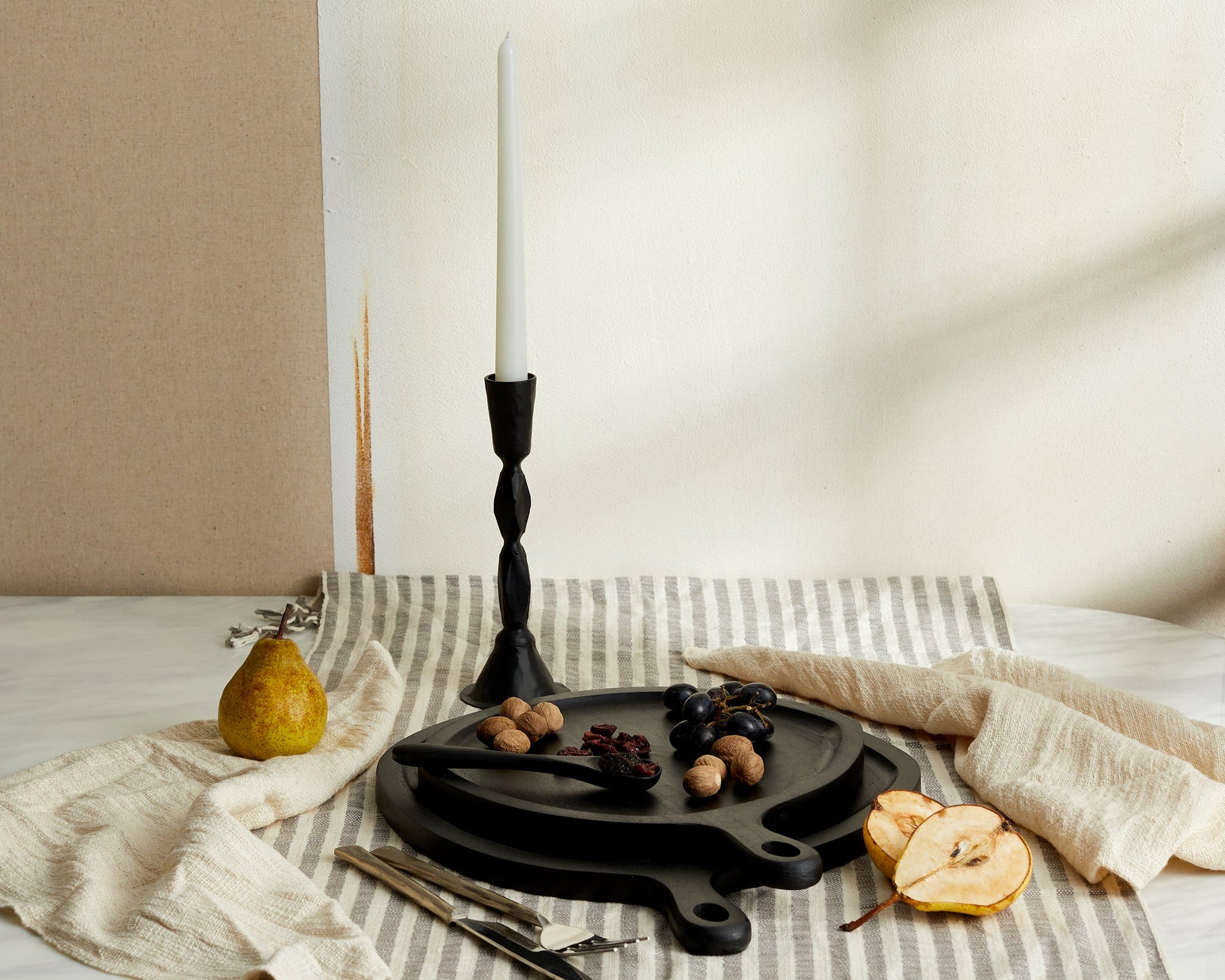 Sculptural black candle holder in blackened brass styled on elegant table setting