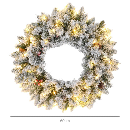 Close-up of snowy 60-inch Christmas wreath with pinecones, berries & warm LED lights — lifelike branches with visible depth and festive scale.