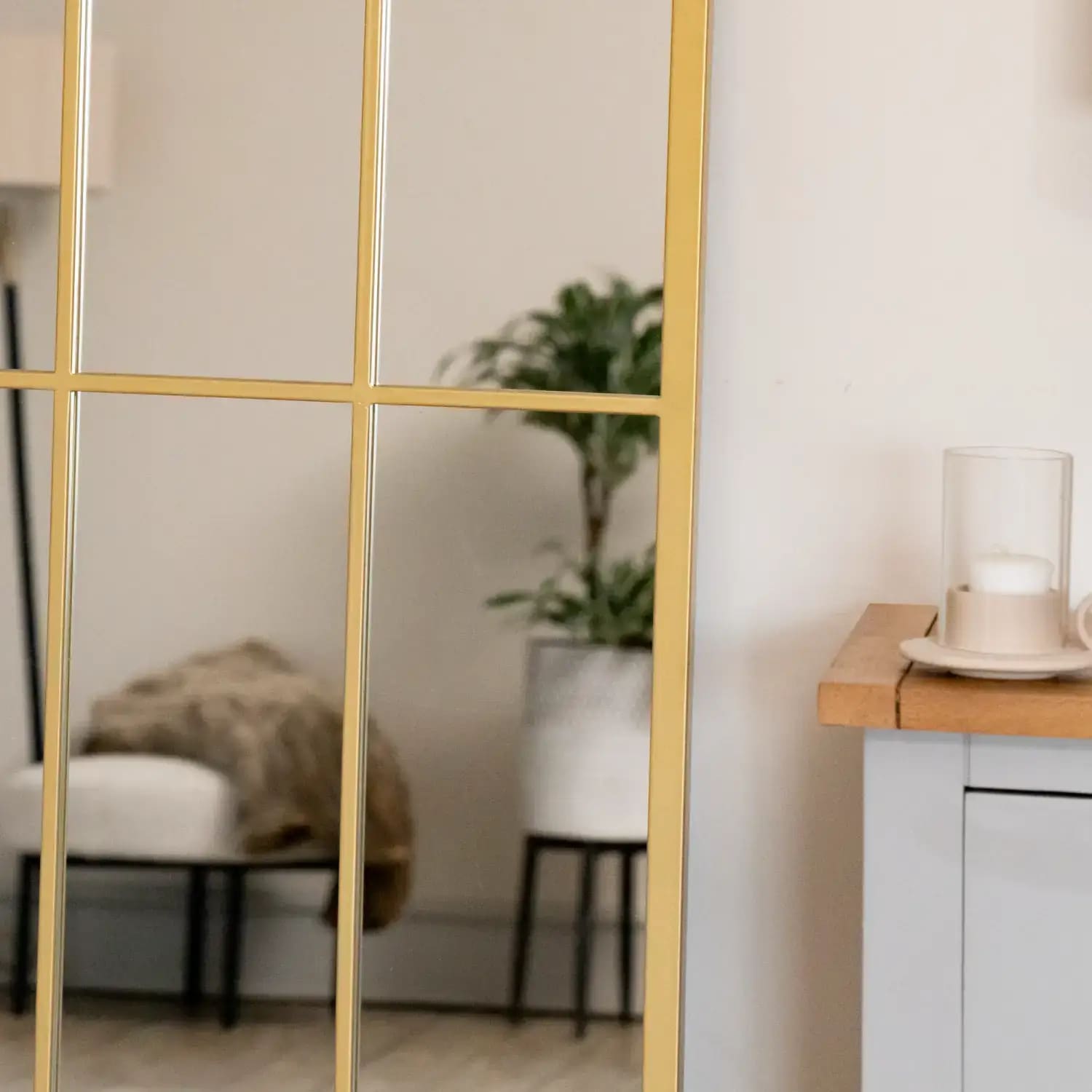 Detail of arched gold mirror frame with lattice design — textured metal finish inspired by heritage architecture