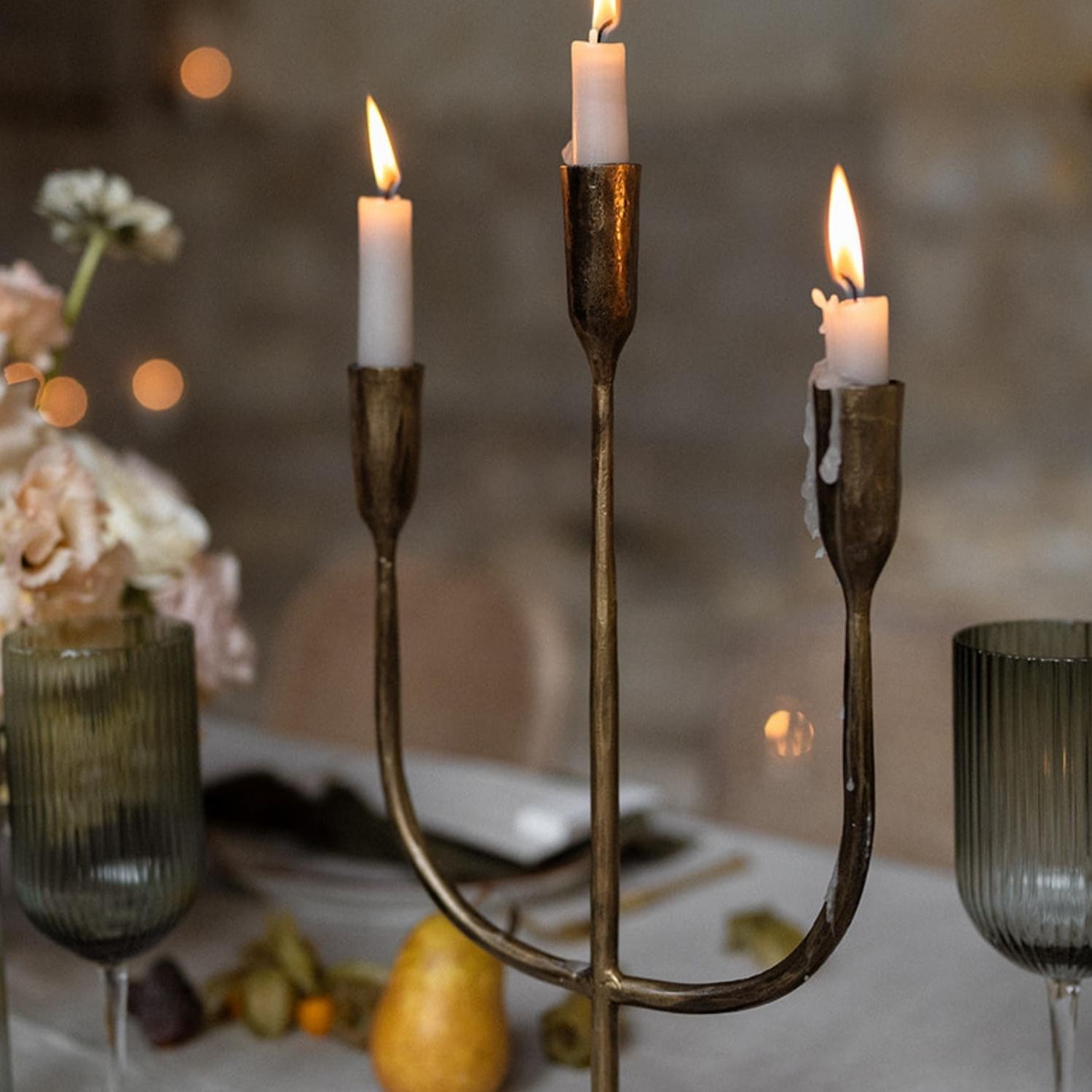 Close view of Weldon gold iron trident candelabra with three taper candles highlighting craftsmanship