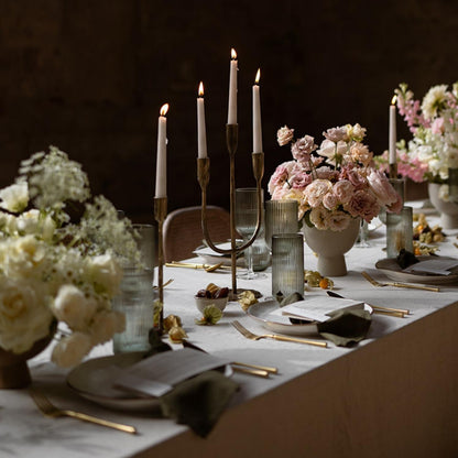 Weldon gold iron trident candelabra with three taper candles as centerpiece on a wedding table