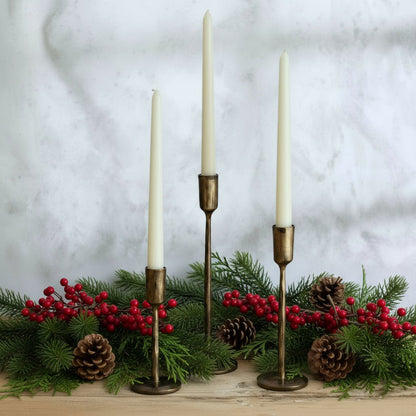 Weldon Iron Candle Holder Set – hand-forged solid iron in antique brass finish, styled with festive garland for rustic table and mantle glow